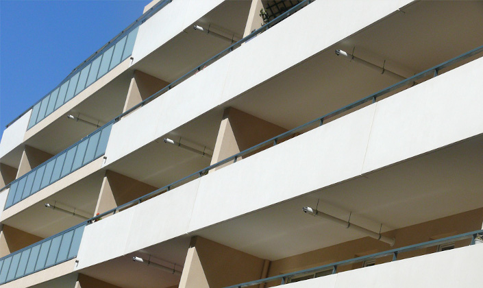 Vue de la façade blanche du bâtiment handitoît à Marseille. Une enfilade de balcons couverts sur 4 étages.
