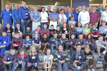 Photo de "classe" de l'outil en main. Les seniors et les enfants posent face à l'appareil photo. 